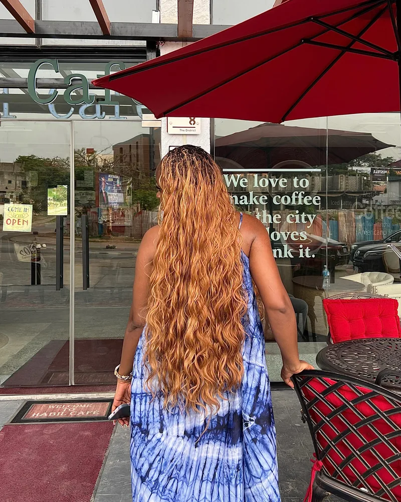 Worthy in a blue dress outside a café