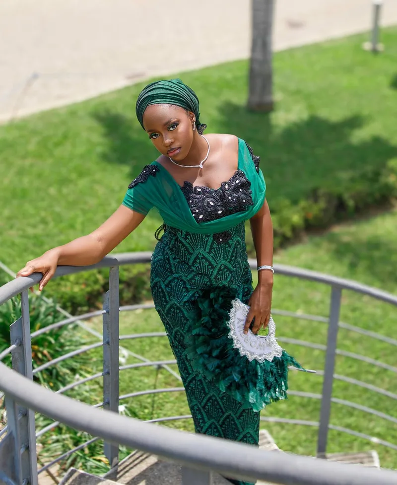 Worthy in a green dress and matching headwrap